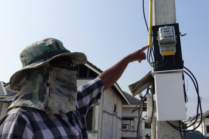 A woman points to an electric meter in Chonburi province on April 21, 2020.