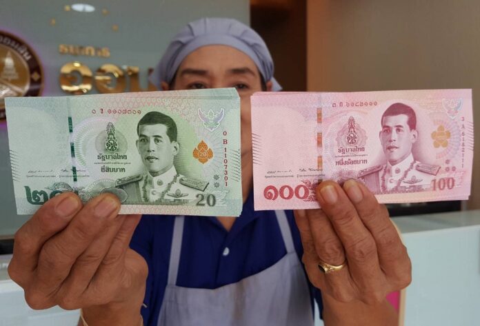 A vendor holds up new banknotes at a bank on April 6, 2018.