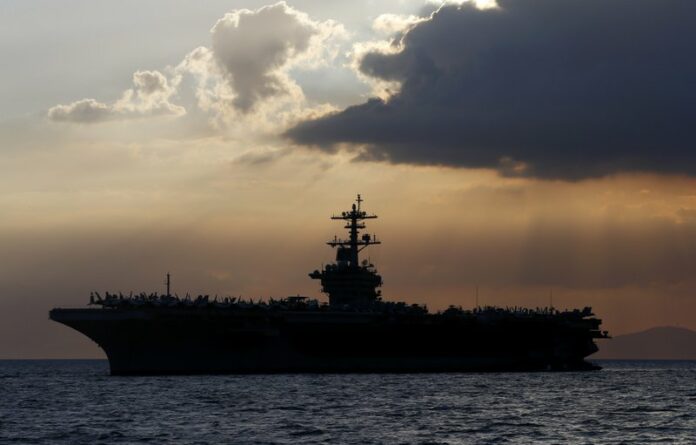 In this April 13, 2018, file photo the USS Theodore Roosevelt aircraft carrier is anchored off Manila Bay west of Manila, Philippines. (AP Photo/Bullit Marquez, File)
