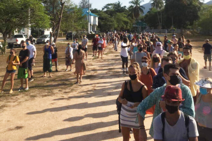 People queue up at a temporary immigration office on Koh Phangan on April 8, 2020. Photo: Richard Barrow / Twitter