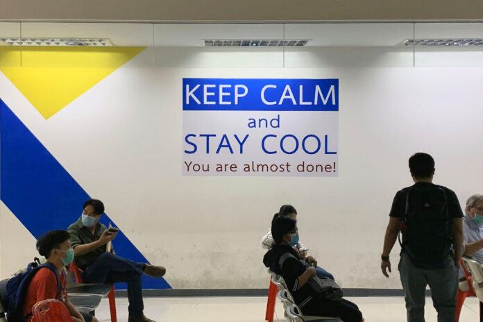 A sign posted at the Immigration Bureau’s main office inside the Government Complex in Chaengwattana telling visitors to be patient. Photo: @CKucway / Twitter