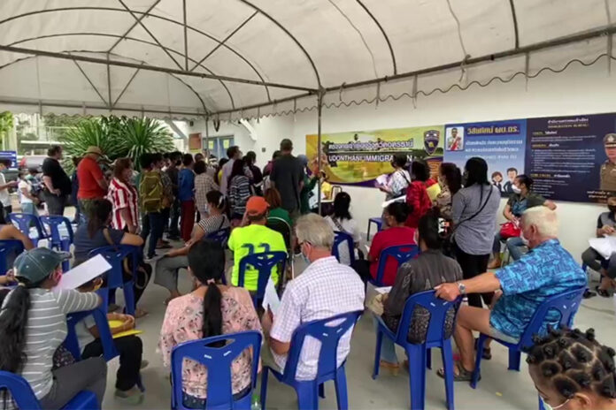 People queue up at a immigration office in Udon Thani province on April 7, 2020.