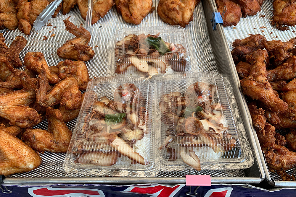 Fried chicken rice sold in plastic boxes at Aut's roadside stall.