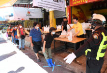 Top Prosecutor Suggests Dropping Charges Against Relief Givers People observe social distancing measures by keeping distance from each other at a food handout event in Bangkok on April 21, 2020.