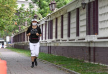 Bangkok Restaurants, Salons, and Parks To Reopen, But No Date Fixed A woman jogs outside Lumpini Park.