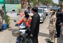 Daily Reported Infections Fall to 28; But 2 More Died of Virus Prime Minister Prayut Chan-o-cha checks the temperature of a motorcyclist during his visit to a checkpoint on April 12, 2020.