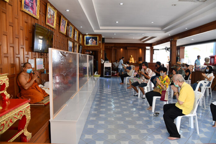 Monks and devotees practice social distancing during a merit making ceremony at Wat Samian Nari in Bangkok on April 13, 2020.