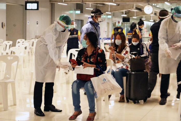 A health official in protective clothing talks to a woman at a health quarantine checkpoint at Suvarnabhumi Airport on April 16, 2020. A health official in protective clothing talks to a woman at a health quarantine checkpoint at Suvarnabhumi Airport on April 16, 2020.