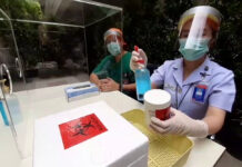 2 More Medical Workers Infected With Coronavirus A nurse at Bhumibol Adulyadej Hospital disinfects a biohazard container on April 28, 2020.