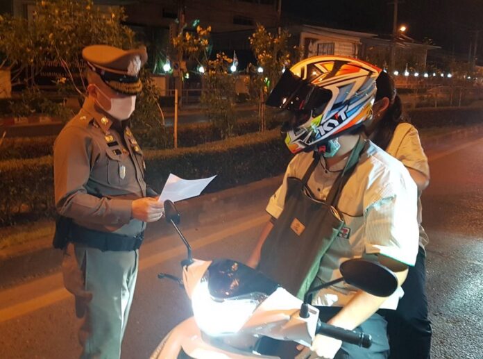 A policeman question curfew violators in Bangkok on April 5, 2020.