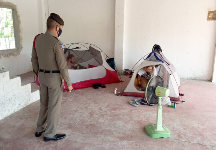A Tourist Police officer questions the three stranded Russian tourists in Phuket on April 5, 2020.
