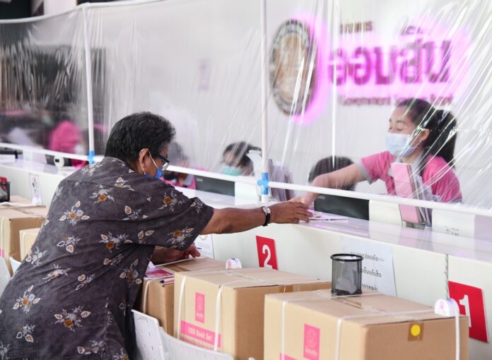 A customer communicates to a bank teller through a plasic screen to prevent coronavirus infection in Bangkok on April 6, 2020.