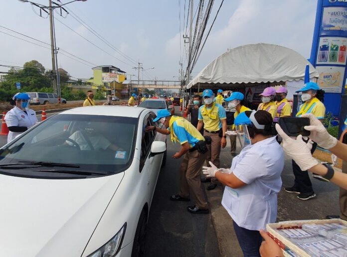Officials hand out face masks to motorists in Nonthaburi province on April 14, 2020.