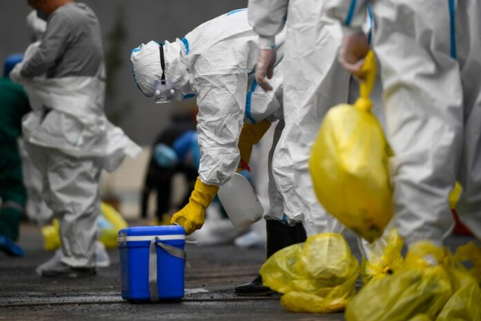 A medical worker disinfects a box containing COVID-19 samples for nucleic acid test at the center for disease control and prevention in Fengman District of Jilin City, northeast China's Jilin Province, May 17, 2020. Photo: Yan Linyun / Xinhua