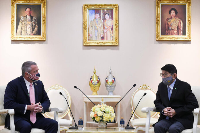 U.S. Ambassador Michael George DeSombre, left, discusses with deputy prime minister Wissanu Krea-ngam, right, during an official visit to the Government House on May 27, 2020.