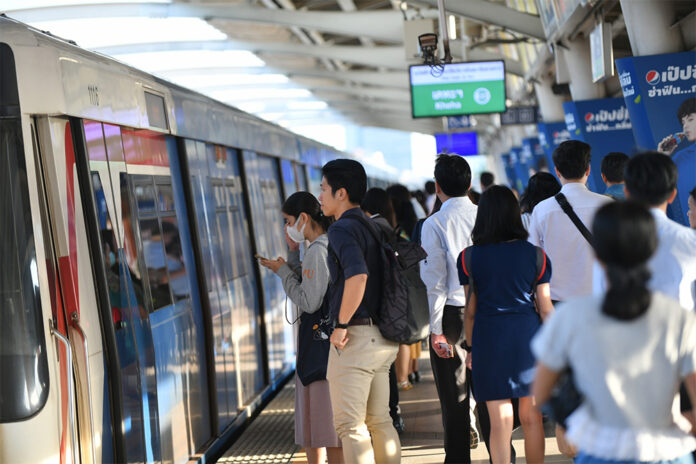 Commuters wait for a train at a BTS station.