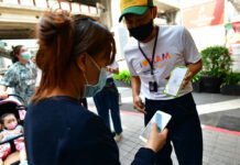 Data Protection Law Suspended Due to Pandemic A customer at Siam Paragon uses her phone to scan the QR code logging her visit with a government website on May 17, 2020.