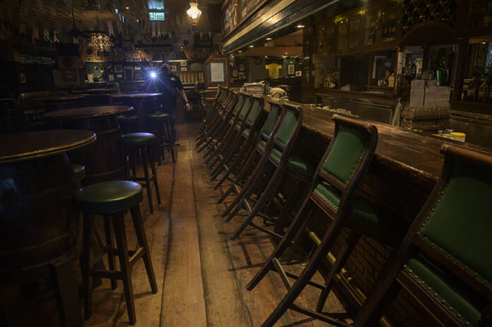 In this April 21, 2020, file photo, a security guard is seen walking a round of patrol in the empty interior of Mulligan's, a popular Irish bar on Khaosan Road. Photo: Sirachai Arunrugstichai In this April 21, 2020, file photo, a security guard is seen walking a round of patrol in the empty interior of Mulligan's, a popular Irish bar on Khaosan Road. Photo: Sirachai Arunrugstichai