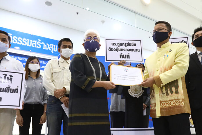 Sec-gen of the Children, Youth and Family Foundation Ticha Na Nagara delivers a petition to justice minister Somsak Thepsutin on May 12, 2020.