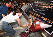 Pandemic Forces Redshirt Crackdown Vigil to Move Venue Khattiyah Sawasdipol lights a candle during a candlelit vigil for her father in front of an entrance of MRT Lumphini on May 13, 2020.