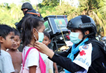 Single-Digit Count in New Virus Cases for 8th Day A member of paramilitary rangers in Narathiwat province puts on a face mask to a girl during a humanitarian operation on May 11, 2020.