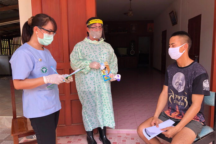 An Aor Sor Mor village health volunteer accompanies a doctor during a house visit in Nong Khai province on May 7, 2020.