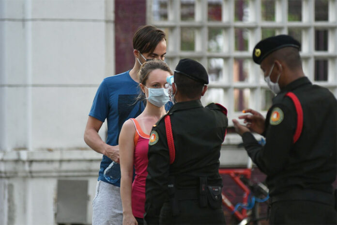 A woman gets her temperature checked before entering Lumpini Park on May 3, 2020. A woman gets her temperature checked before entering Lumpini Park on May 3, 2020.