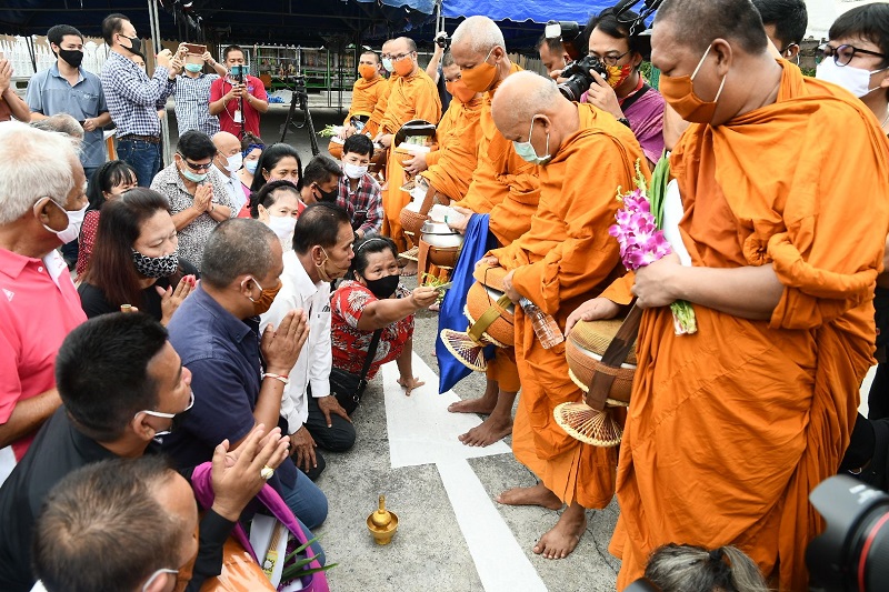 Jatuporn Prompan and his supporters give alms to monks.