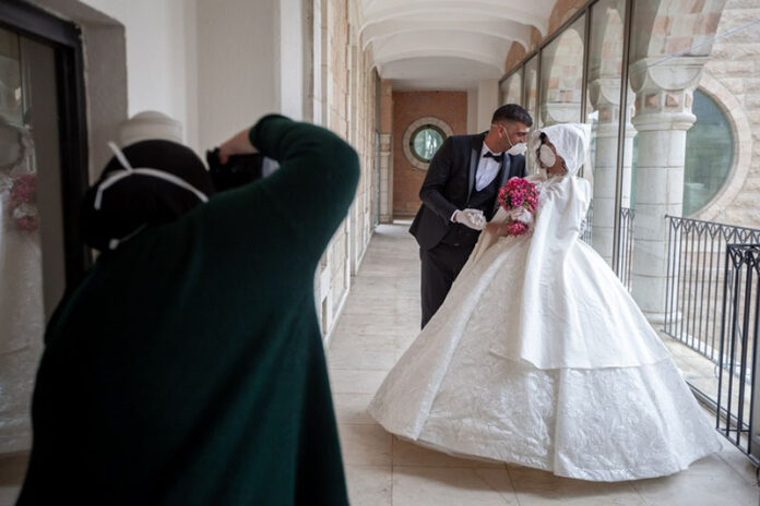 A Palestinian photographer takes pictures for the groom, Ishaq Musleh, and his bride, Shima' al-Titi, in the Palestinian Deheisheh refugee camp near the West Bank city of Bethlehem, on April 10, 2020. Photo: Luay Sababa / Xinhua