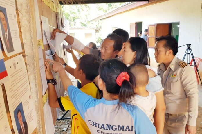 A file photo of people checking the names of eligible voters for an election.