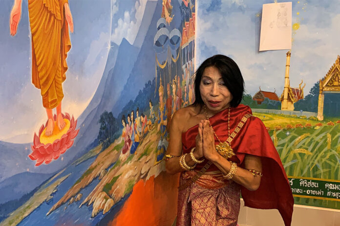 Sitang Buathong stands next to the mural at Wat Nong Tao on June 3, 2020.