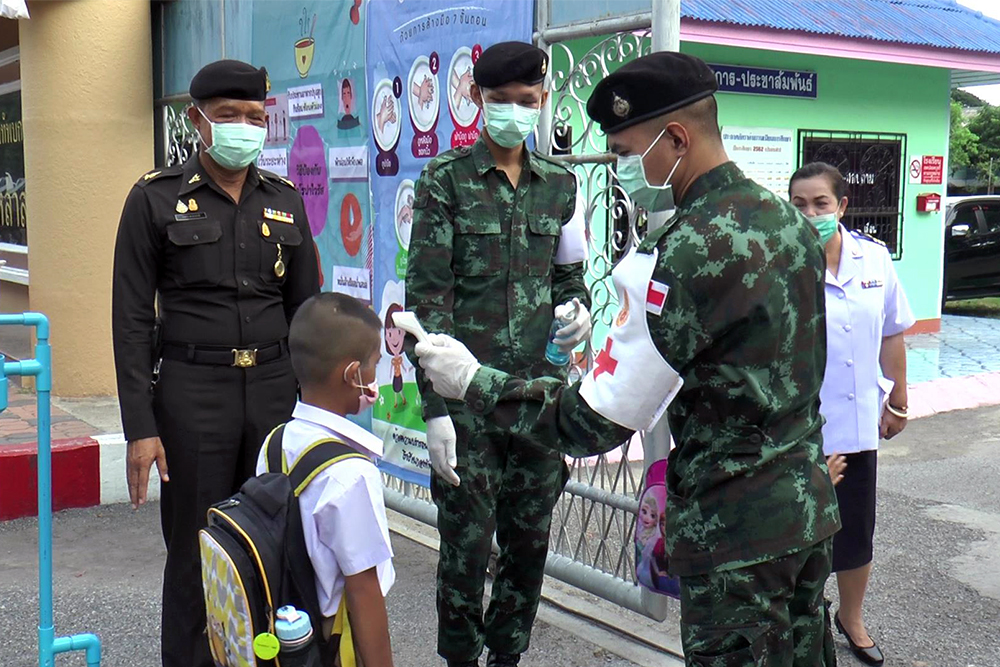 A student gets his temperature checked by a corpsman at Kongthapbok Uppatham Song Lao Sang School in Lopburi province.