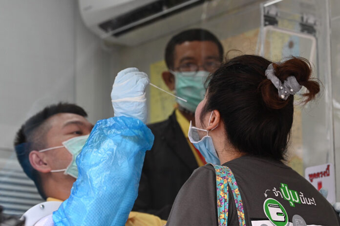 A woman takes a swab test for the coronavirus at a mobile testing unit in front of Laem Thong Department Store on July 14, 2020. A woman takes a swab test for the coronavirus at a mobile testing unit in front of Laem Thong Department Store on July 14, 2020.