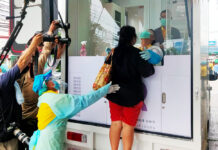 Rayongers Queue up for Virus Test, Gov. Removed Over SNAFU A woman takes a swab test for the coronavirus at a mobile testing unit in front of Laem Thong Department Store on July 14, 2020.