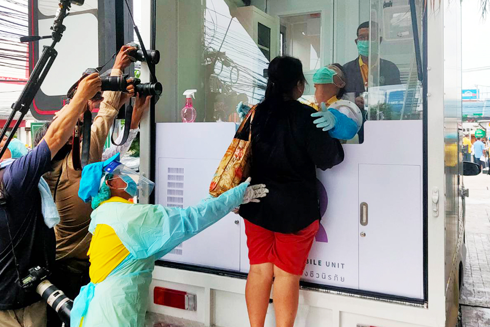 A woman takes a swab test for the coronavirus at a mobile testing unit in front of Laem Thong Department Store on July 14, 2020.
