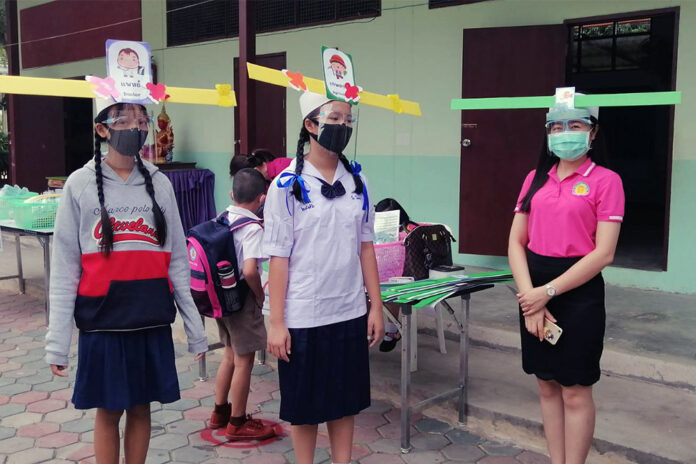 Students and teachers wear face shields based on a headwear worn by ancient Chinese scholars at Baan Pa Maud School in Chiang Mai province.