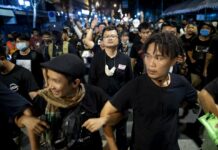 No Arrest at Sunday’s Protest Despite 12 Warrants Pro-democracy activist and human rights lawyer Arnon Nampha, center, and student leaders walk to a police station in anticipation of arrest after a protest rally at Democracy Monument in Bangkok, Thailand, Sunday, Aug, 16, 2020. Photo: Gemunu Amarasinghe / AP