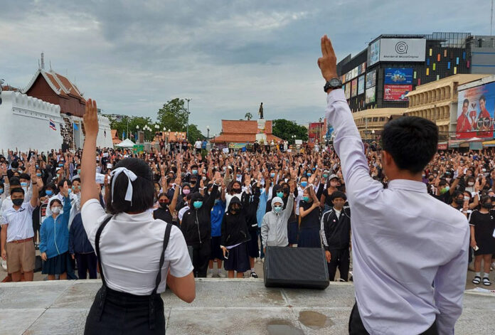 Students hold up the three-finger salute at a pro-democracy protest in Korat city on Aug. 20, 2020.