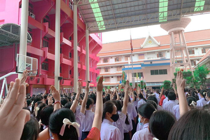 Students at all-female Apsorn Sawan School in Bangkok flash the three-finger salute during the morning flag raising ceremony on Aug. 17, 2020. Photo: @aorwiki / Twitter