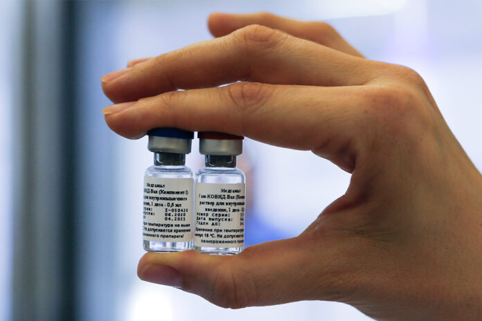 In this handout photo taken on Thursday, Aug. 6, 2020, and provided by Russian Direct Investment Fund, an employee shows a new vaccine at the Nikolai Gamaleya National Center of Epidemiology and Microbiology in Moscow, Russia. Photo: Alexander Zemlianichenko Jr/ Russian Direct Investment Fund via AP