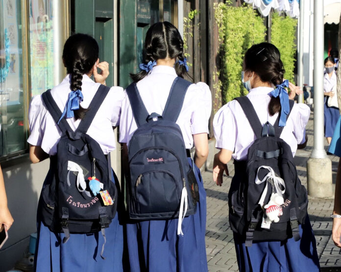 Students at Rajini School tie white ribbons on their bags on Aug. 24, 2020.