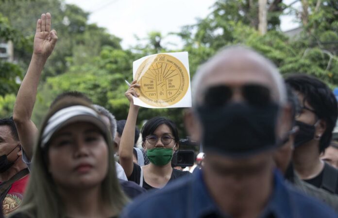 Pro-democracy demonstrators hold a copy of a plaque marking Thailand's transition to democracy during a protest outside the Parliament in Bangkok, Thailand, Thursday, Sept. 24, 2020. Lawmakers in Thailand are expected to vote Thursday on six proposed amendments to the constitution, as protesters supporting pro-democratic charter reforms gathered outside the parliament building. Photo: Sakchai Lalit / AP
