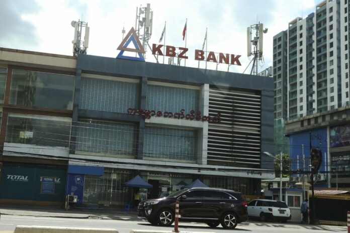 A vehicle passes by in front of a Kanbawza bank branch Thursday, Sept. 10, 2020, in Yangon, Myanmar. The Kanbawza Group, or KBZ, is one of Myanmar’s largest conglomerates, with businesses in a variety of sectors including construction, finance, manufacturing, agriculture, trading, insurance, aviation and jade and ruby mining and joint ventures with Myanmar Economic Holdings, a huge conglomerate that an Amnesty International report says is supporting military units and individuals involved in human rights abuses. (AP Photo/Thein Zaw)