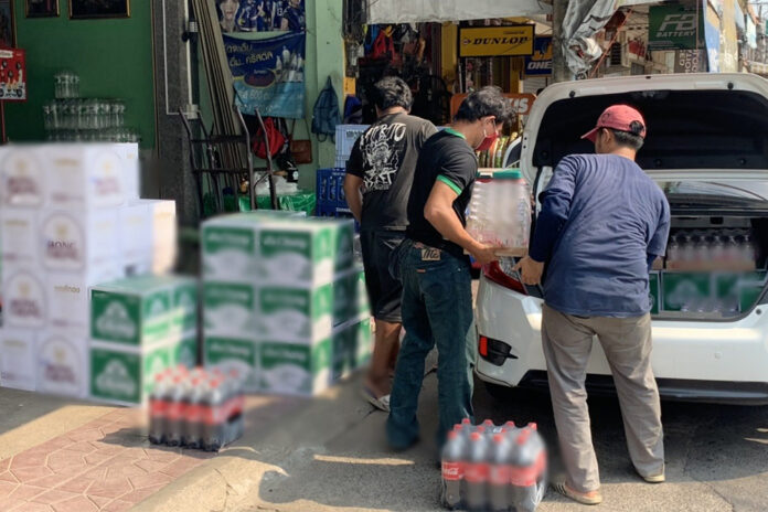 A man in Sisaket province loads crates of beer and soda water into a vehicle on May 3, 2020. The image was censored due to legal concerns.
