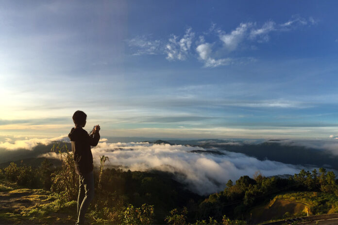 A tourist takes photos of the sea of fog on top of Doi Inthanon in 2017.
