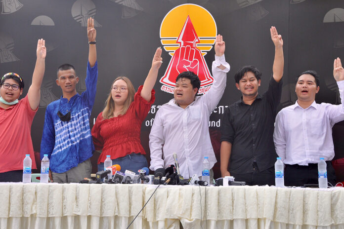 Parit Chiwarak, Panusaya Sithijirawattanakul, and other activists flash the anti-military “three finger salute” at a news conference at Thammasat University on Sept. 9, 2020.