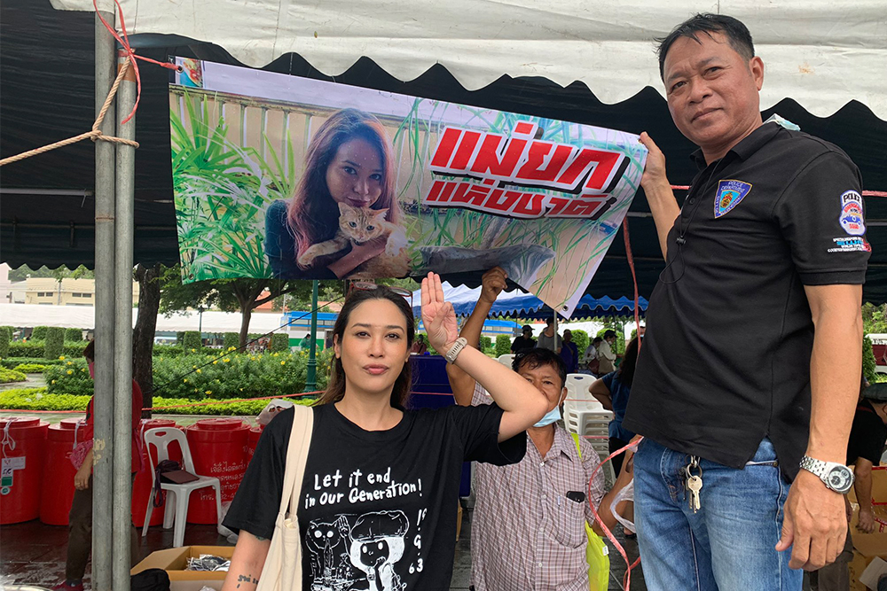 Actress Intira “Sai” Charoenpura flashes the three-finger salute in front of the field kitchen during a protest on Sept. 20, 2020. Photo: @charoenpura / Twitter