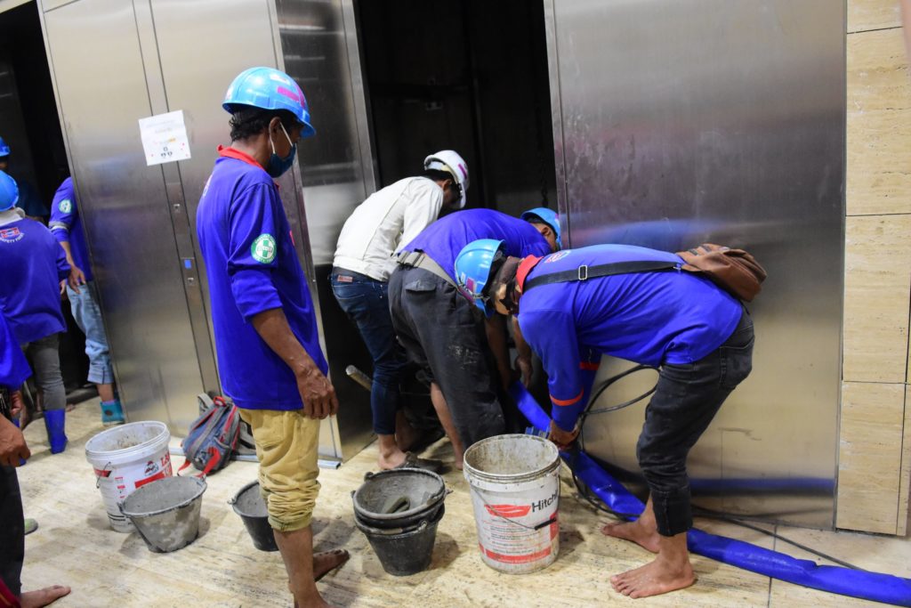 Workers drain water from an elevator inside the parliament building.