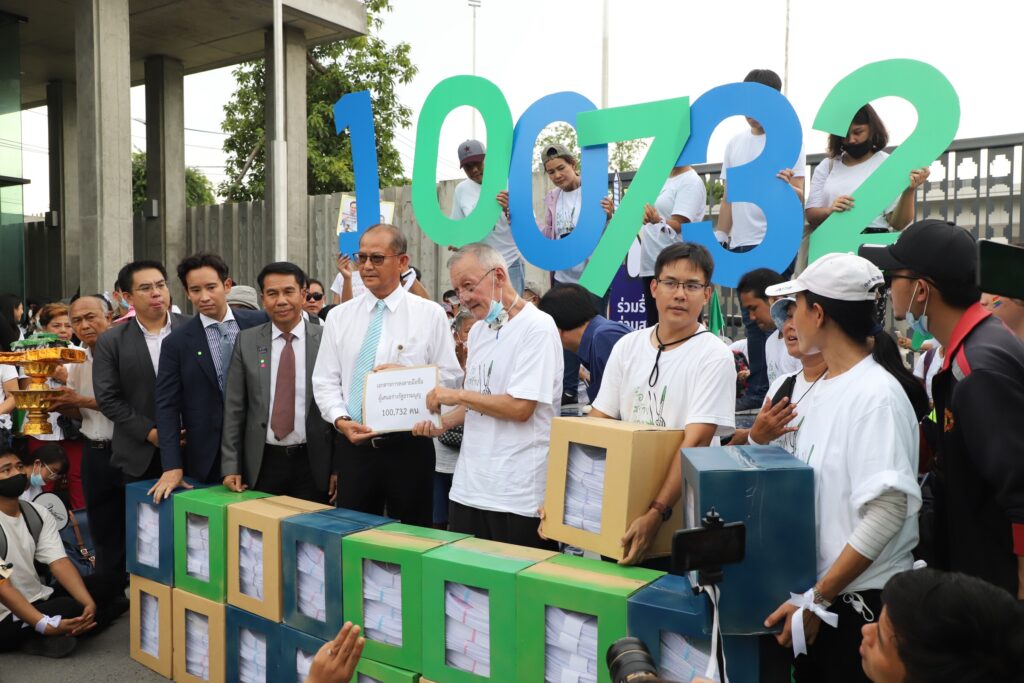 iLaw director Jon Ungphakorn, center, submits a petition for Constitution amendments to Somboon Uthaiwiankul, secretary to the House Speaker, left, in front of the parliament building on Sept. 22, 2020.