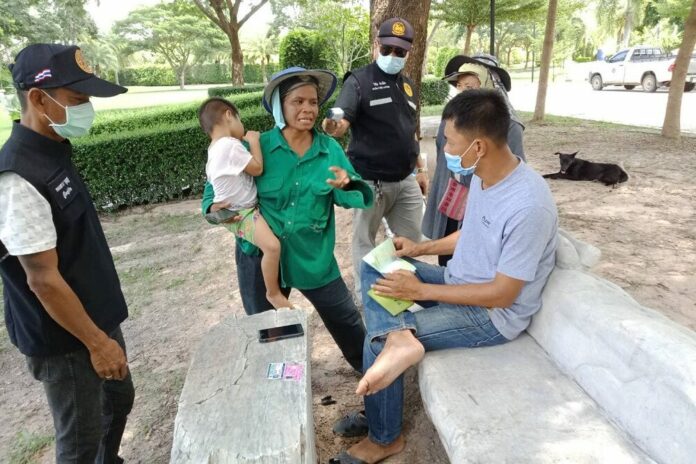 Security officers question a woman and check her temperature in Ratchaburi province on Sep. 6, 2020, in an anti-coronavirus measure that mostly targets migrant workers.